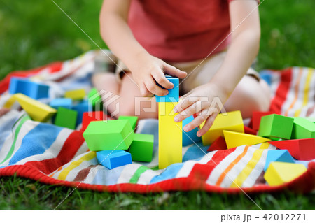 Cute preschooler boy playing with colorful cubes 42012271