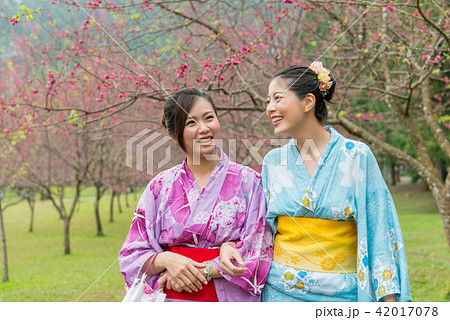 women chat together under the cherry blossom tree 42017078