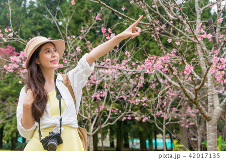 woman pointing front under the cherry tree 42017135