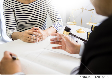 business people and lawyers discussing contract papers sitting a business people and lawyers discussing contract papers sitting a 42018600
