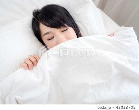girl covers her face with white blanket in morning girl covers her face with white blanket in morning 42023705