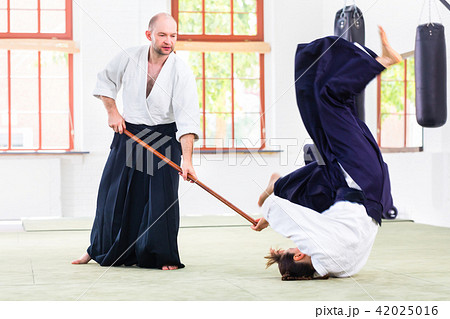 Man and woman having Aikido stick fight Man and woman having Aikido stick fight 42025016