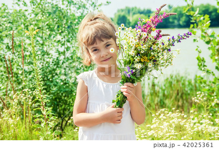 Child with a bouquet of wildflowers. Selective focus. 42025361
