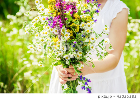 Child with a bouquet of wildflowers. Selective focus. Child with a bouquet of wildflowers. Selective focus. 42025383