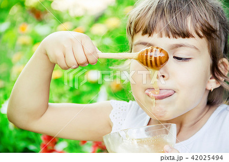 The child eats honey. Selective focus. nature. The child eats honey. Selective focus. nature. 42025494