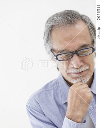 顎に手をあててうつむく眼鏡のシニア男性 顎に手をあててうつむく眼鏡のシニア男性 42026511