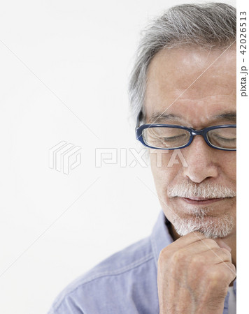 目を閉じて顎に手をあてる眼鏡のシニア男性 42026513