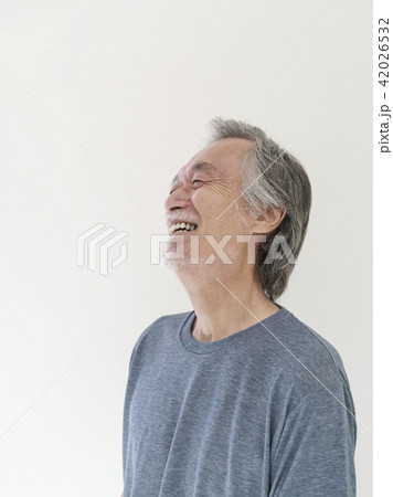 顔を上げて笑うシニア男性の写真素材