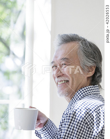 マグカップを持つシニア男性の写真素材