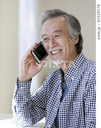 スマートフォンで話すシニア男性 スマートフォンで話すシニア男性 42026578