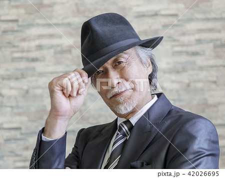 帽子のツバをつまむシニア男性の写真素材