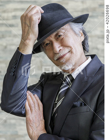 帽子に手を当てるシニア男性の写真素材