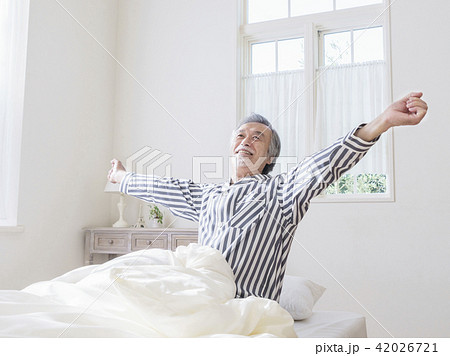 ベッドで背伸びをするシニア男性 42026721