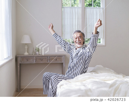 ベッドで背伸びをするシニア男性 ベッドで背伸びをするシニア男性 42026723