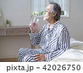 ベッドに座って水を飲むシニア男性 42026750
