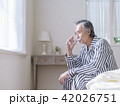 ベッドに座って水を飲むシニア男性 42026751