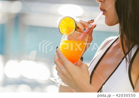 sexy woman near the pool with a cocktail close up sexy woman near the pool with a cocktail close up 42030550