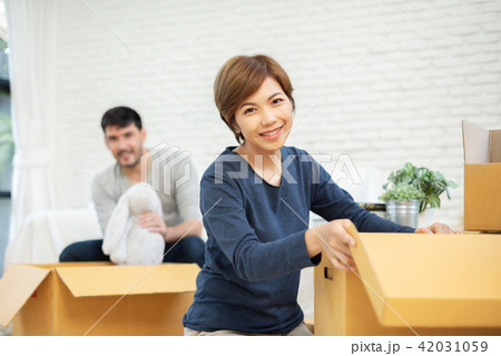 Couple unpacking cardboard boxes at new home.  42031059