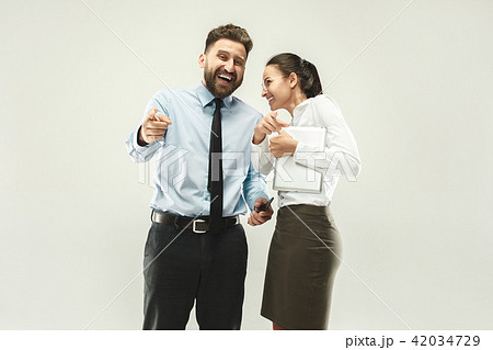 Happy boss. Man and his secretary standing at office Happy boss. Man and his secretary standing at office 42034729