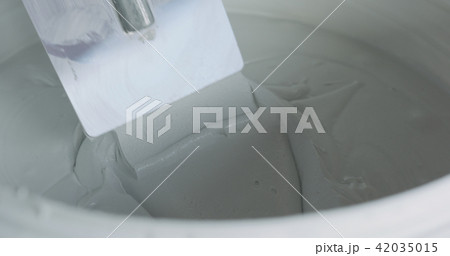 closeup worker dipping the trowel into the decorative concrete plaster 42035015