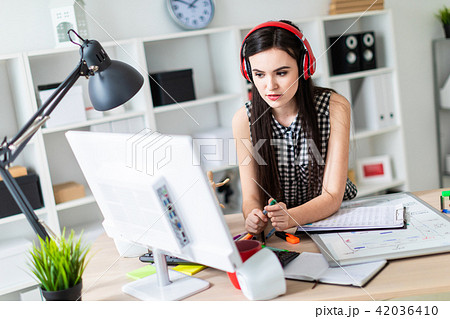 A young girl is standing near a table, holding a green marker and looking at the monitor. Before the A young girl is standing near a table, holding a green marker and looking at the monitor. Before the 42036410