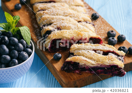 Homemade blueberry puff pastry braid, on blue wood 42036821