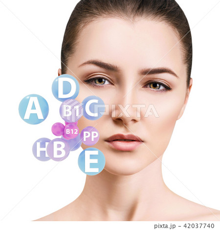 Young woman with vitamins balls near face. 42037740