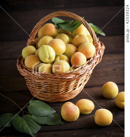Ripe apricots in a brown wicker basket Ripe apricots in a brown wicker basket 42039324