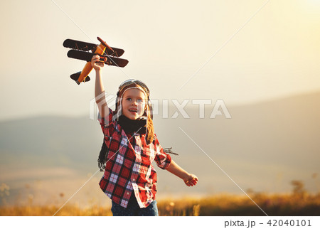 Child pilot aviator with airplane dreams of traveling in summer 42040101