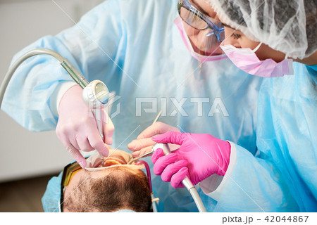 Close-up of dentist and her assistant working with patient teeth 42044867