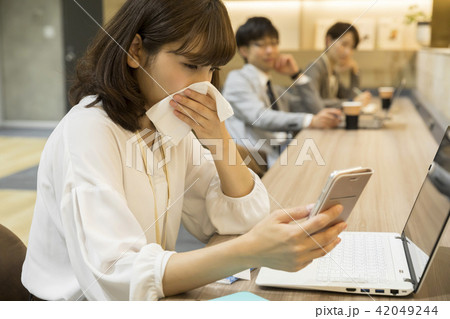 コワーキングスペースで鼻をかむビジネスウーマン 42049244