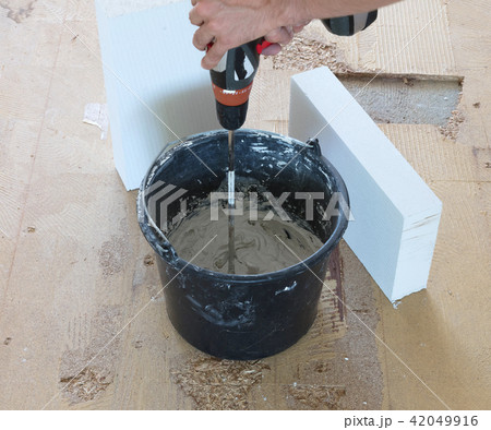 Man is mixing grey concrete and prime  42049916