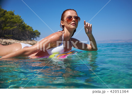 A beautiful young girl lies on a mattress in the open sea 42051364