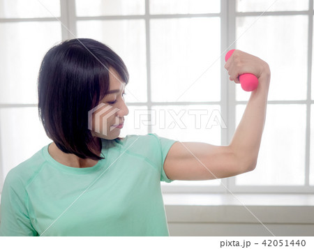 Young girl lifting dumbbells  42051440