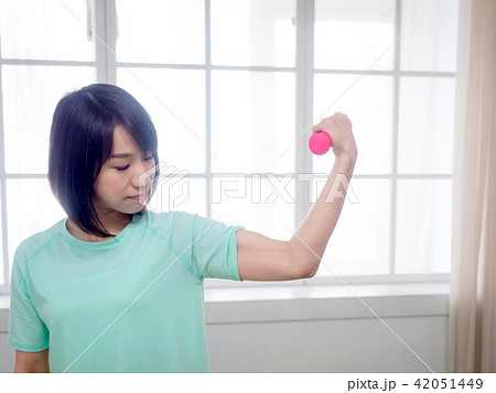 Young girl lifting dumbbells Young girl lifting dumbbells 42051449