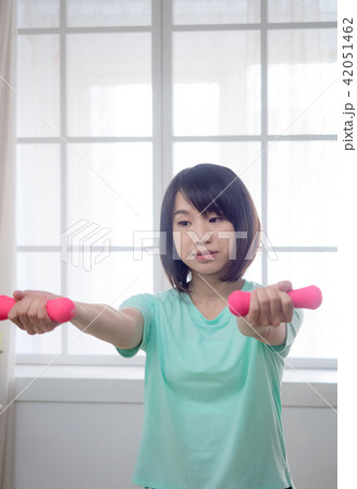 Young girl lifting dumbbells Young girl lifting dumbbells 42051462