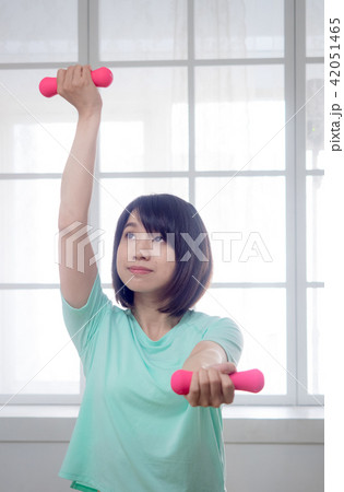 Young girl lifting dumbbells Young girl lifting dumbbells 42051465