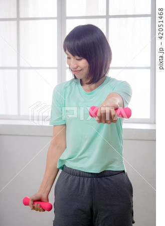 Young girl lifting dumbbells Young girl lifting dumbbells 42051468
