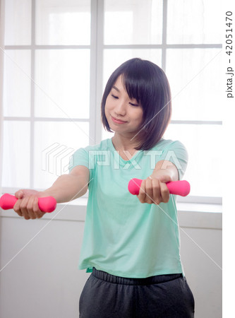Young girl lifting dumbbells  42051470