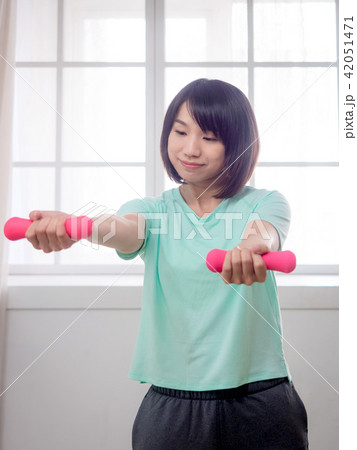 Young girl lifting dumbbells  42051471