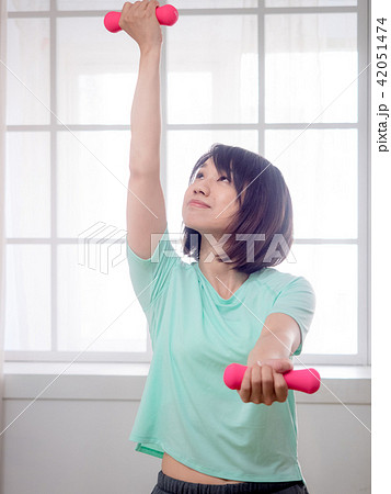 Young girl lifting dumbbells Young girl lifting dumbbells 42051474