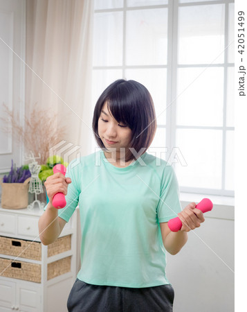 Young girl lifting dumbbells Young girl lifting dumbbells 42051499