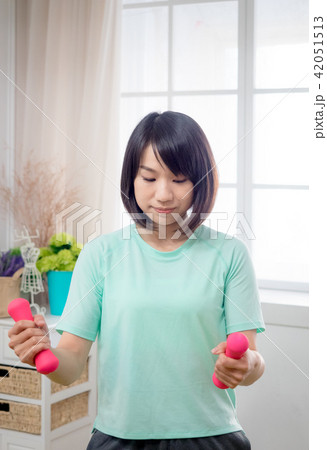 Young girl lifting dumbbells  42051513