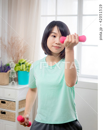 Young girl lifting dumbbells Young girl lifting dumbbells 42051519