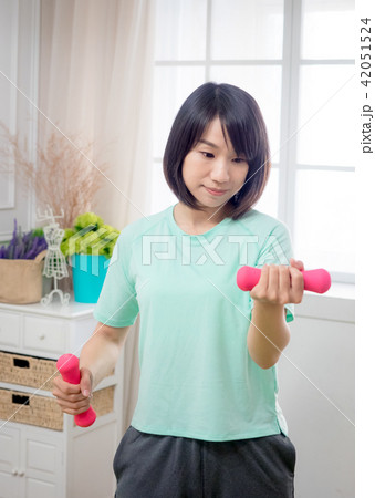 Young girl lifting dumbbells Young girl lifting dumbbells 42051524