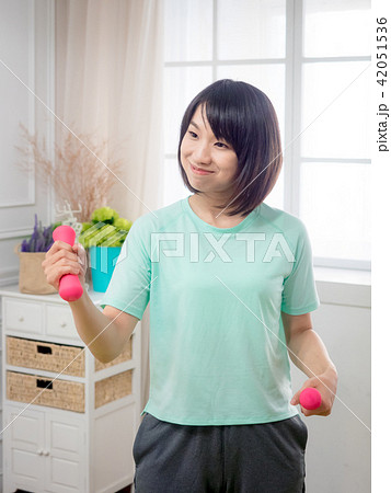 Young girl lifting dumbbells Young girl lifting dumbbells 42051536