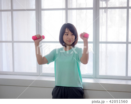 Young girl lifting dumbbells  42051560