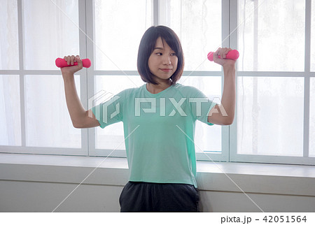 young girl lifting dumbbells  42051564