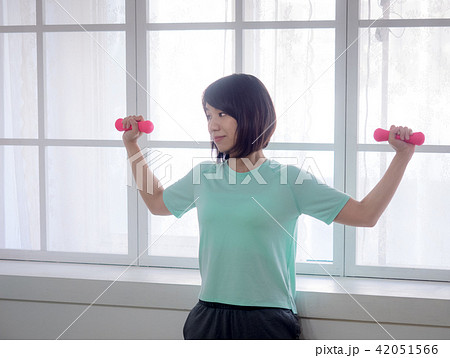 young girl lifting dumbbells  42051566
