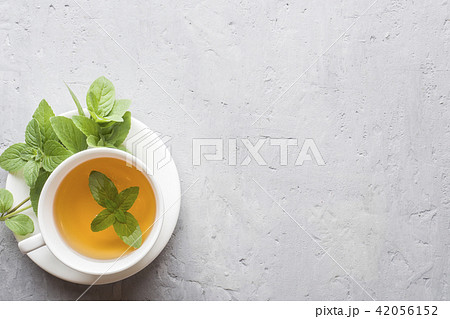 Cup of tea with fresh mint leaves on grey concrete 42056152